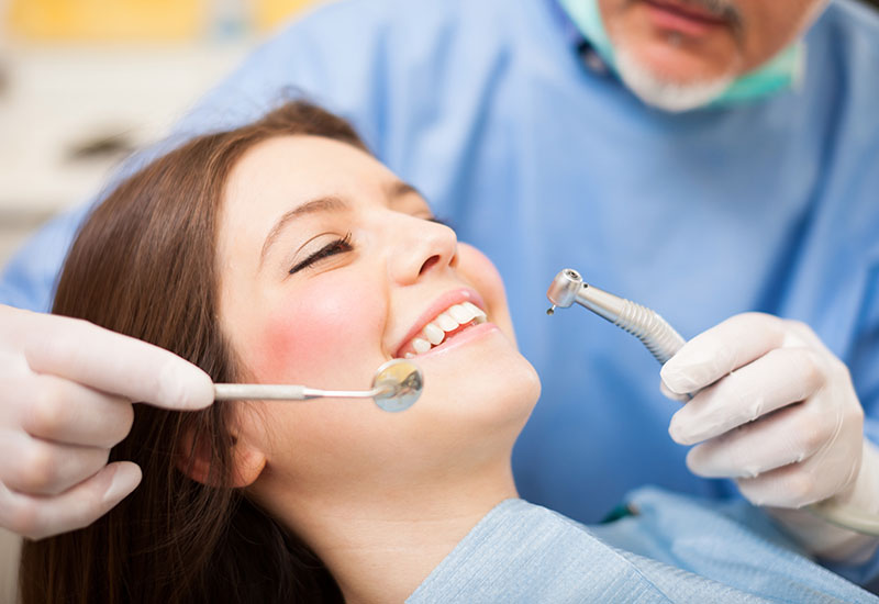 Bei einer jungen Frau wird eine Endodontiebehandlung durchgeführt.