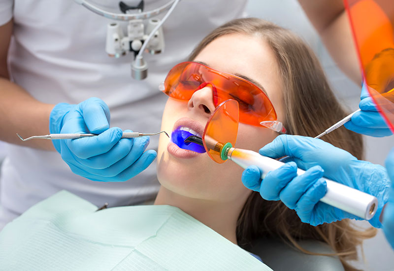 Bei einer jungen Frau wird eine Fissurenversiegelung durchgeführt.